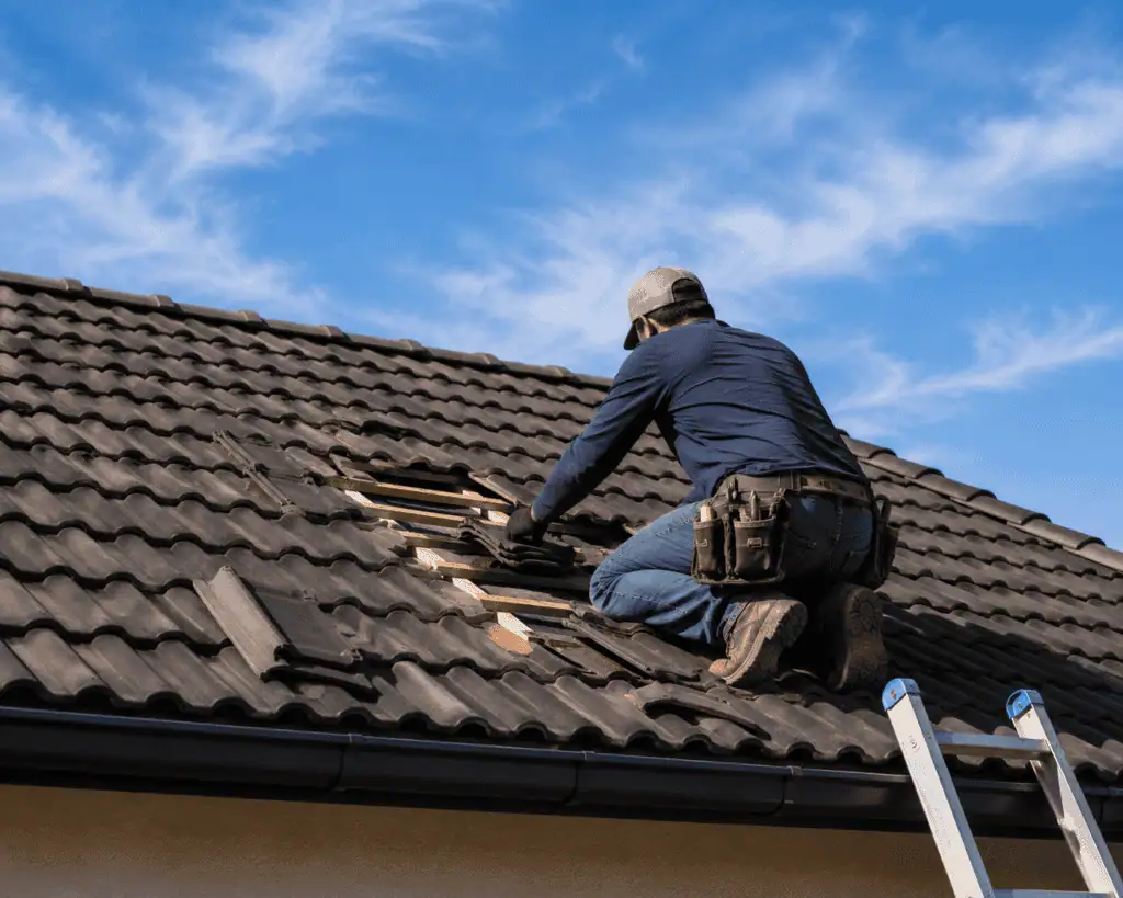 Roofer repairing damaged roof tiles on residential home.